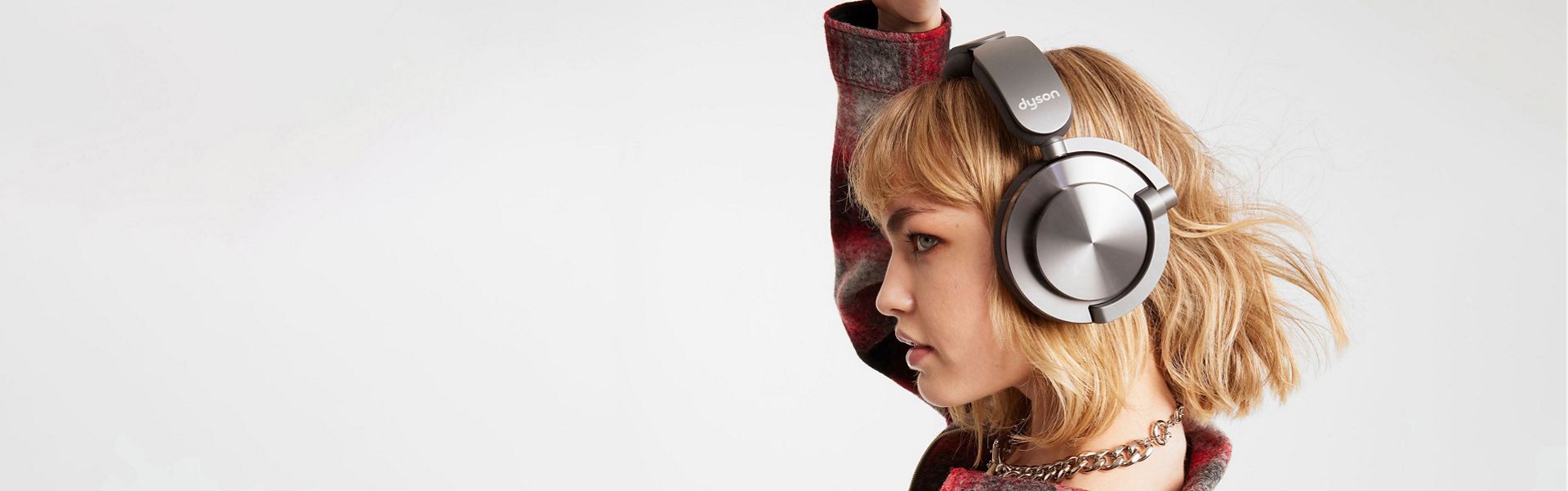 Young woman in profile wearing Ontrac headphones, arm raised as though dancing
