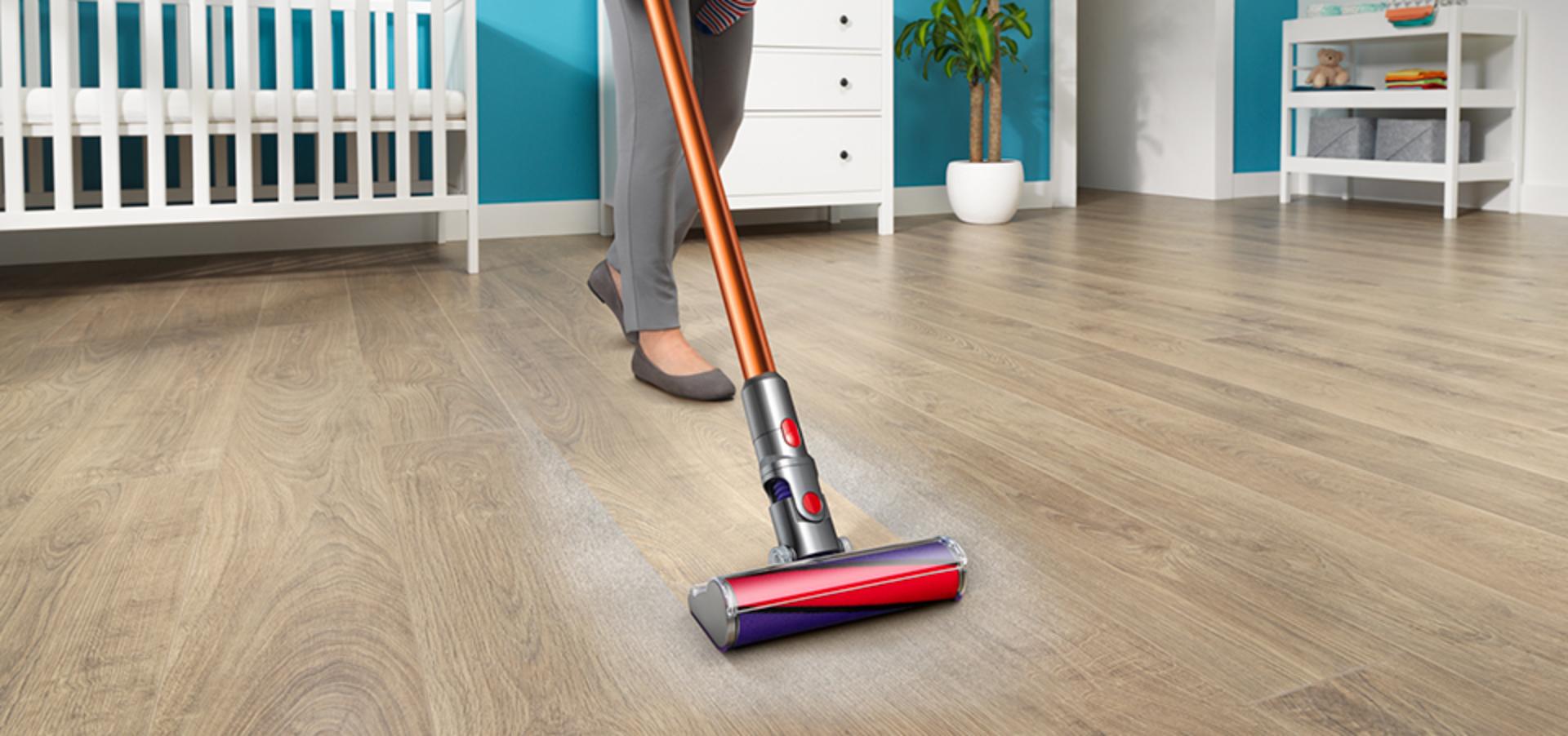 Osoba odkurzająca podłogę odkurzaczem Dyson z elektroszczotką fluffy