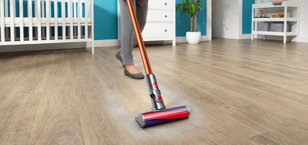 Osoba odkurzająca podłogę odkurzaczem Dyson z elektroszczotką fluffy