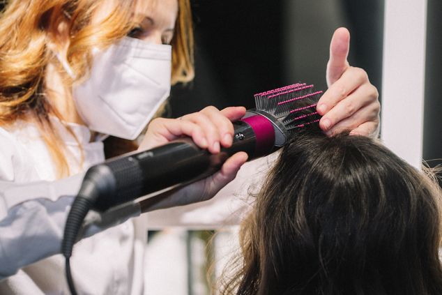 Stylistin nutzt den Dyson Airwrap Haarstyler an einer Kundin