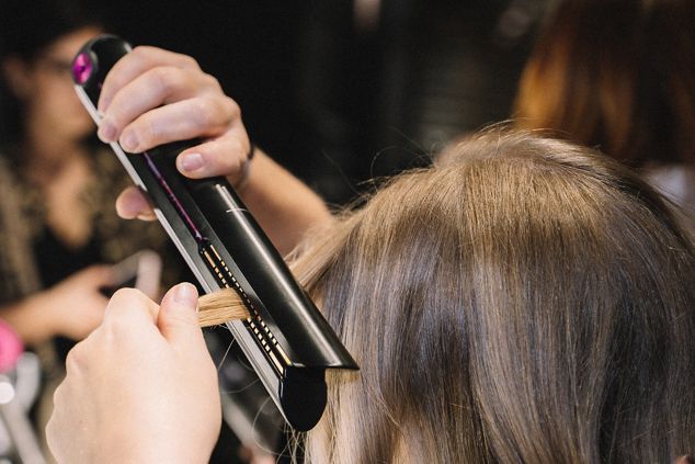 Eine Frau benutzt einen Dyson Corral Haarglätter um ihre Haare zu stylen