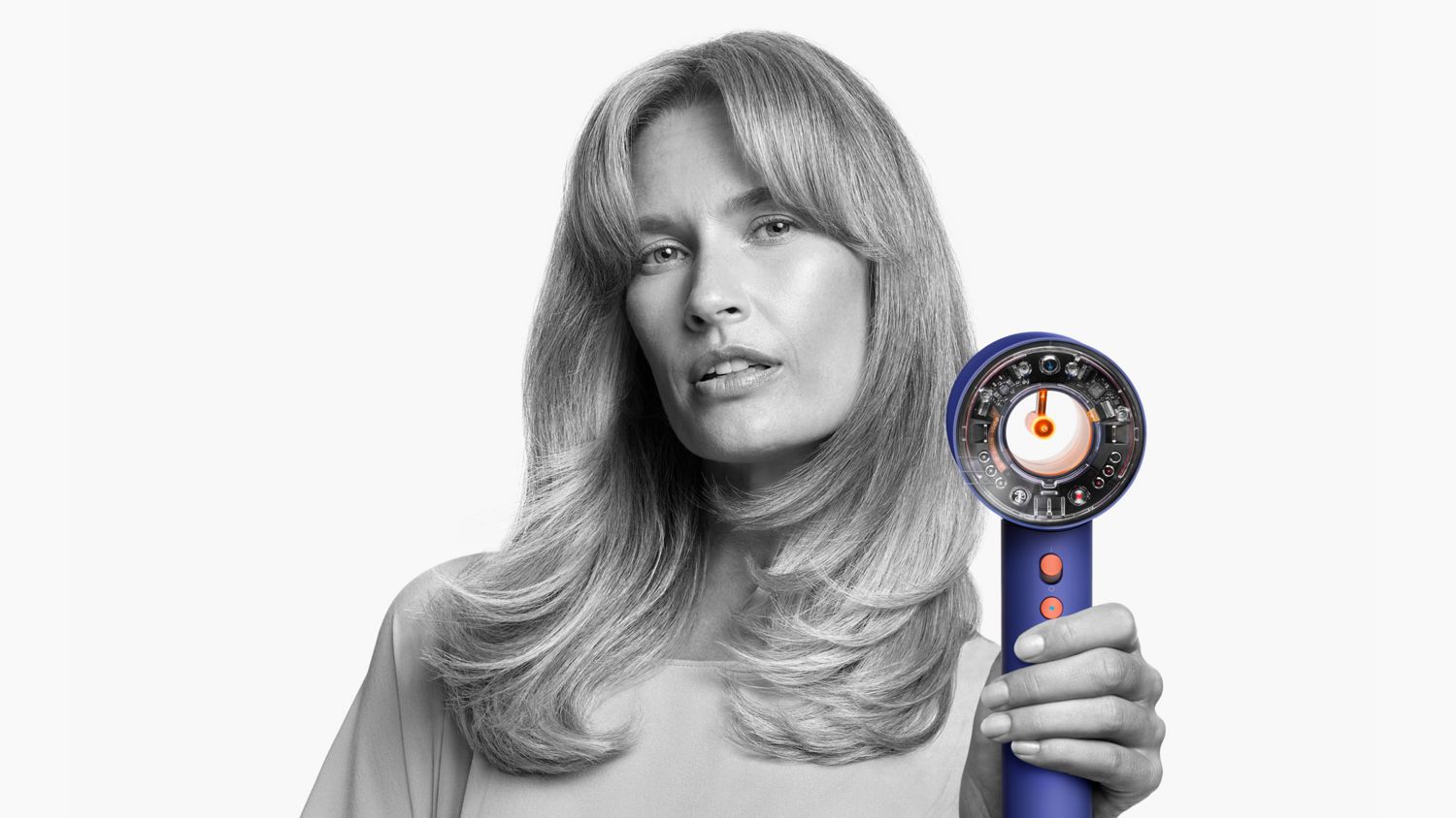 A model holding the Dyson Supersonic Nural hair dryer.