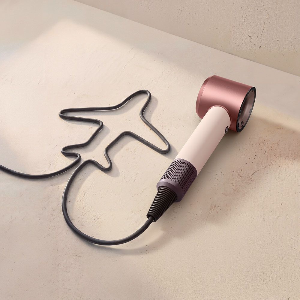 Dyson Supersonic Reisehaartrockner mit einem Kabel in Form eines Flugzeugs.
