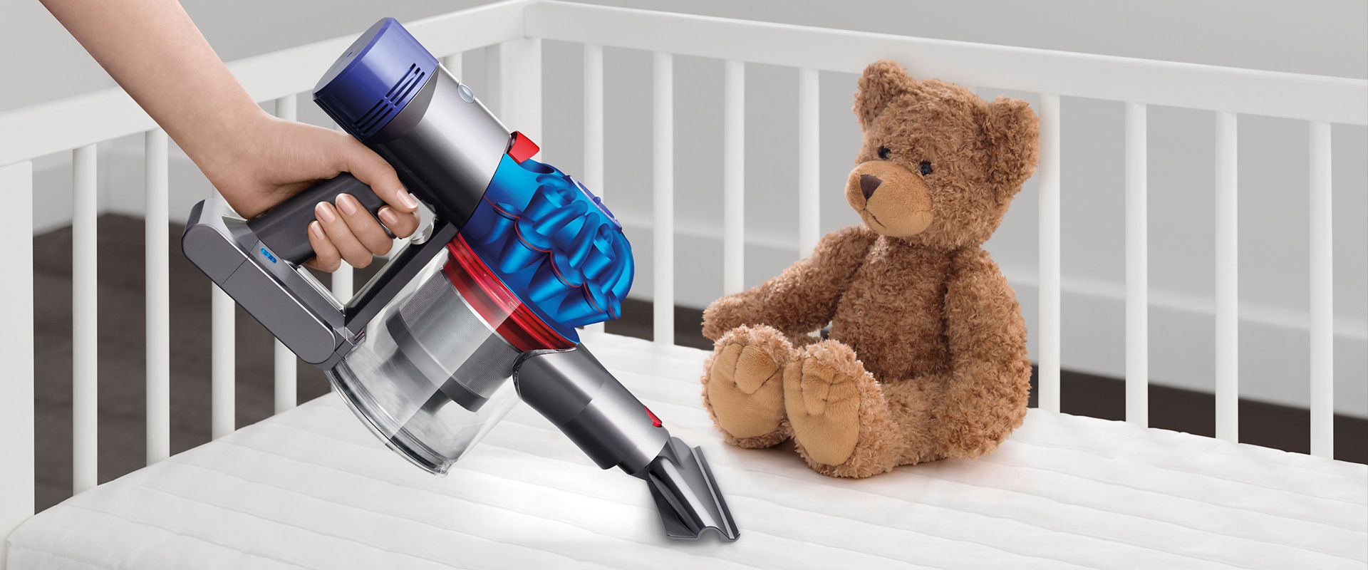 Dyson vacuum cleaner in the handheld mode cleaning a child's bed.