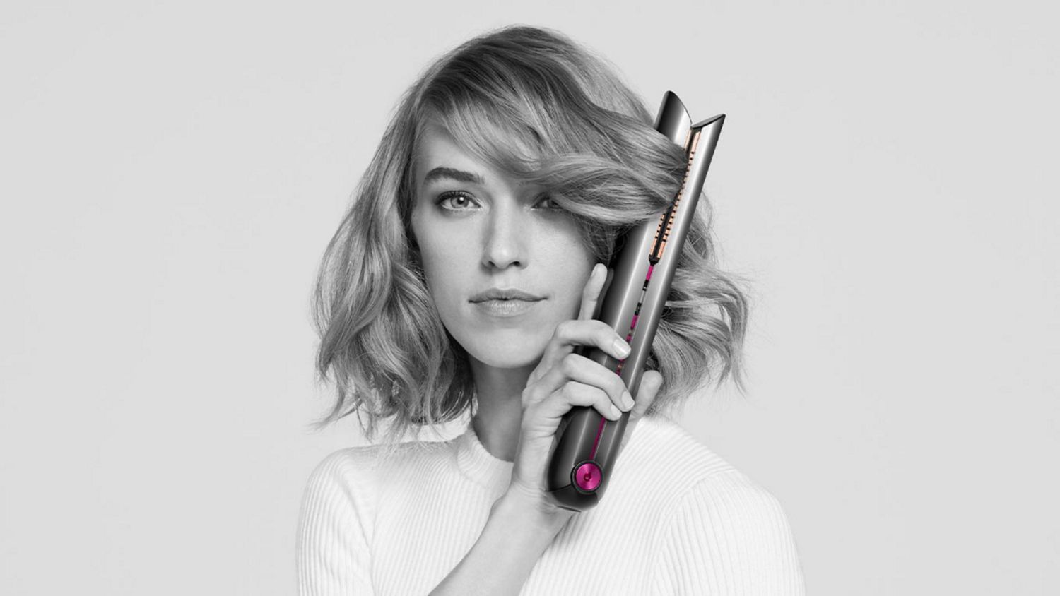 Dyson coralle hair straightener used by model to curl hair 