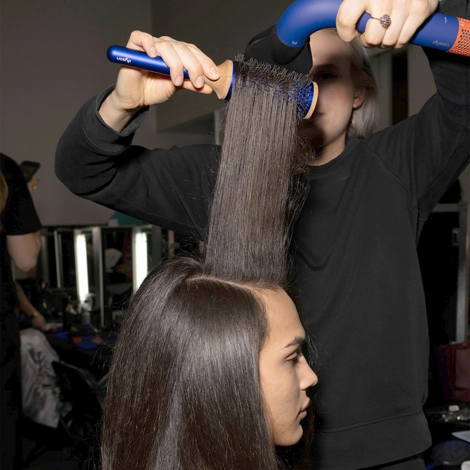 Gros plan sur le sèche-cheveux Dyson Supersonic r utilisé pour coiffer un mannequin dans les coulisses de la Paris Fashion Week