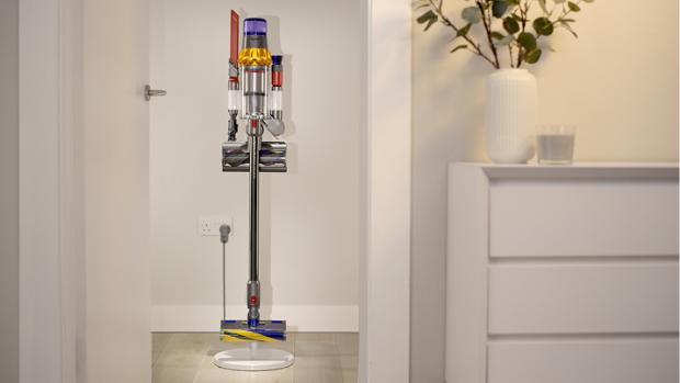 A Dyson vacuum and accessories mounted and charging on a Floor dock.