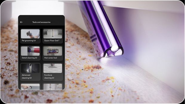 A Dyson Light pipe crevice tool cleans a hard-to-reach gap with an app screen showing a range of tools and accessories.
