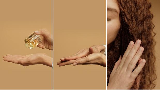 Olejek nawilżający do włosów Dyson Omega nakładany na dłoń i wcierany we włosy