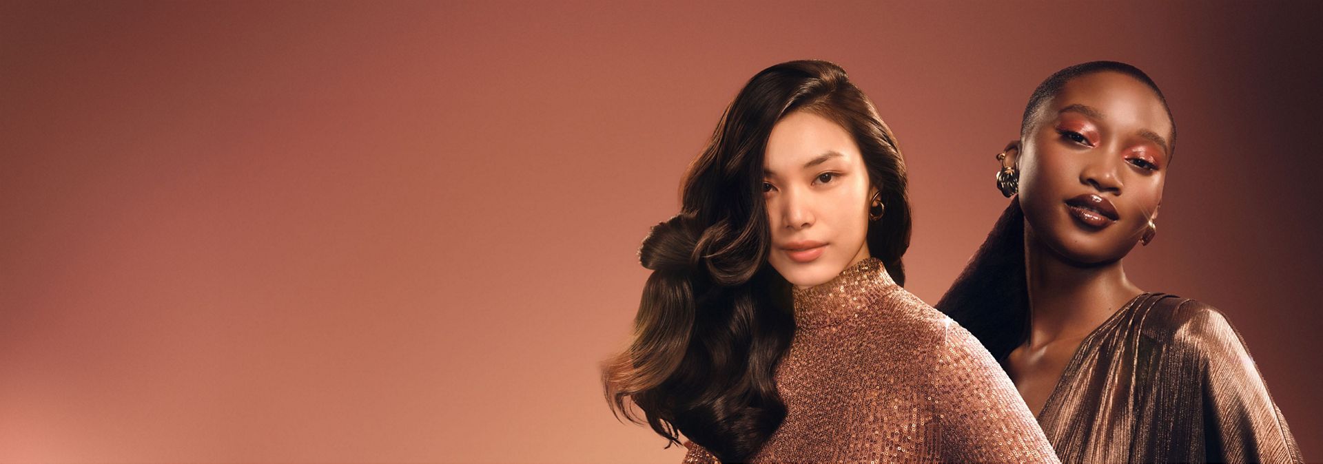 Dwie modelki z pięknymi fryzurami stylizowanymi przy użyciu urządzeń Dyson