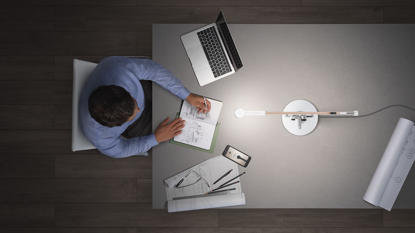 A man working from home using a Dyson Lightcycle Task Light 