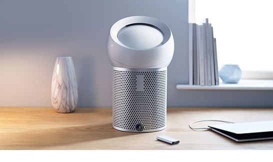 Dyson Pure Cool Me purifying fan on a desk with a remote control 