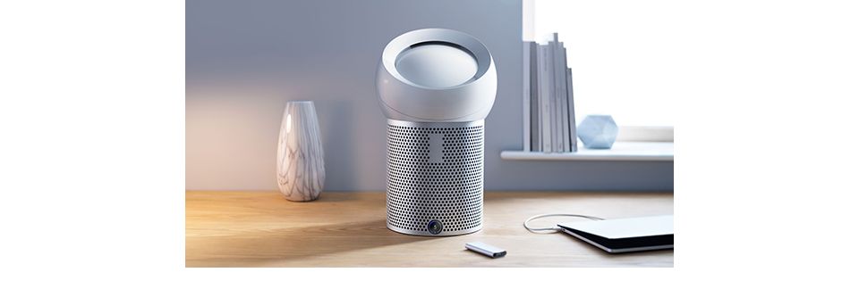 Dyson Pure Cool Me purifying fan on a desk with a remote control 
