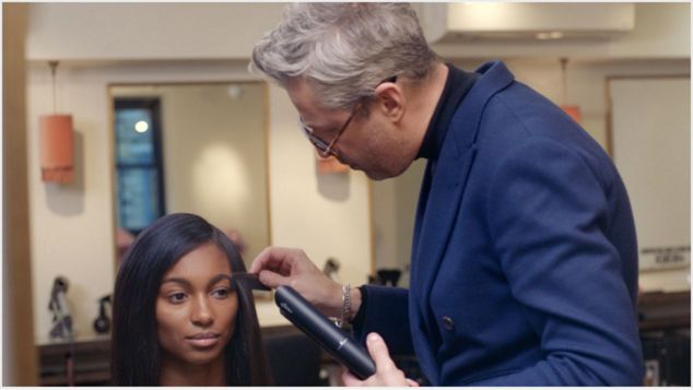 Stylist styling model's hair. Stylist styling model's hair.