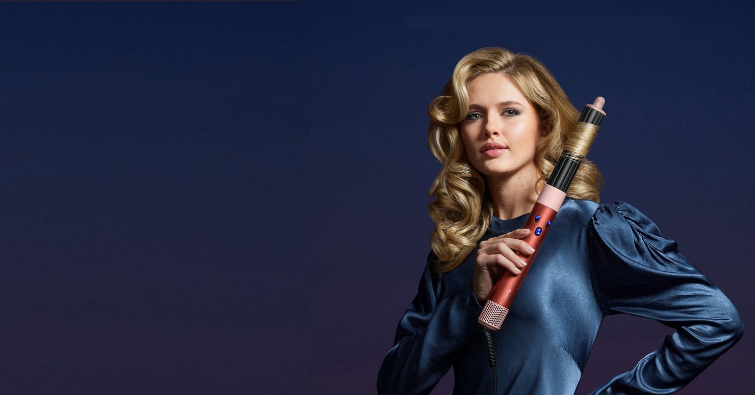 Dyson Airwrap i.d. multi-styler and dryer adding curls to a model's long, blonde hair.