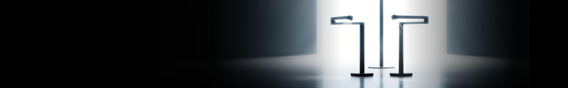 A lineup of sleek Dyson appliances, including vacuums, hair tools, and an air purifier, arranged in a dark room.