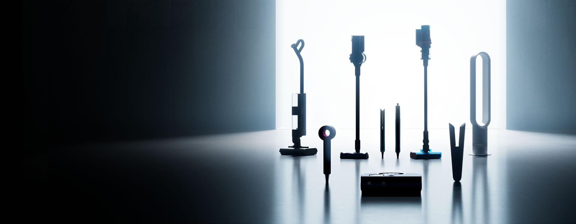 A lineup of sleek Dyson appliances, including vacuums, hair tools, and an air purifier, arranged in a dark room.