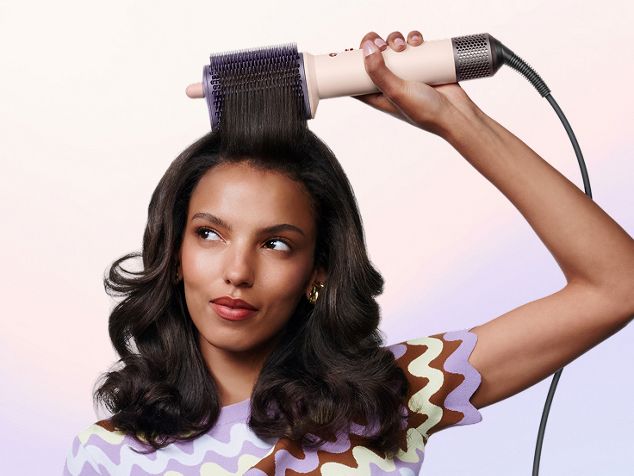 La modelo peina su cabello con el cepillo de peinado Dyson Airsmooth.