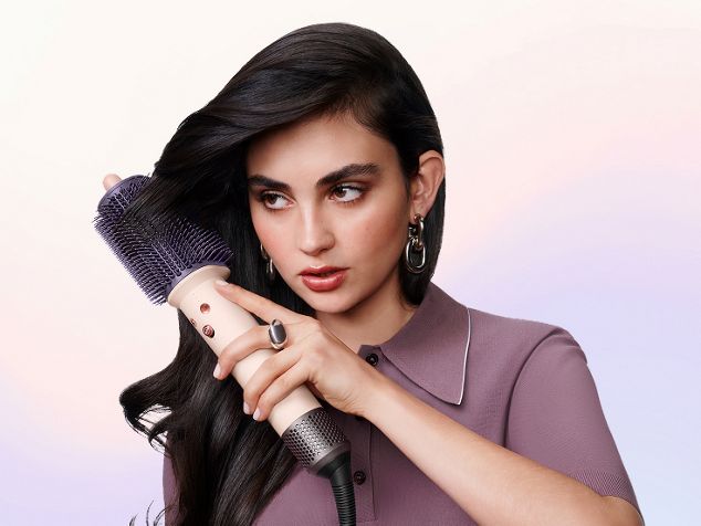 La modelo cepilla su cabello con el cepillo de peinado Dyson Airsmooth.