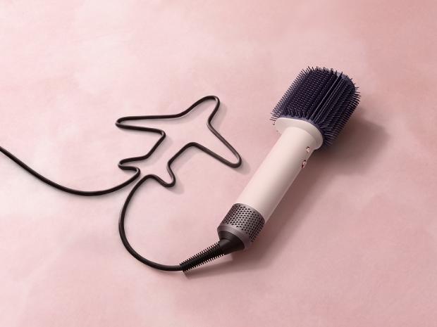 Model styles her hair with the Dyson Airsmooth styling brush.