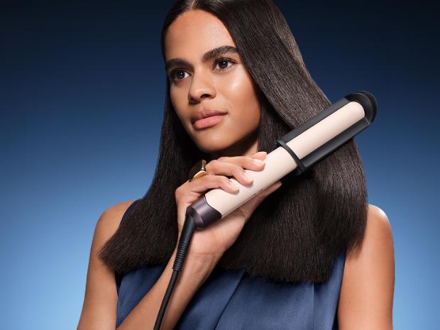 Model straightens her hair with the Dyson Corrale CoolShine hair straightener. in the Dyson Big Ball cylinder vacuum range.