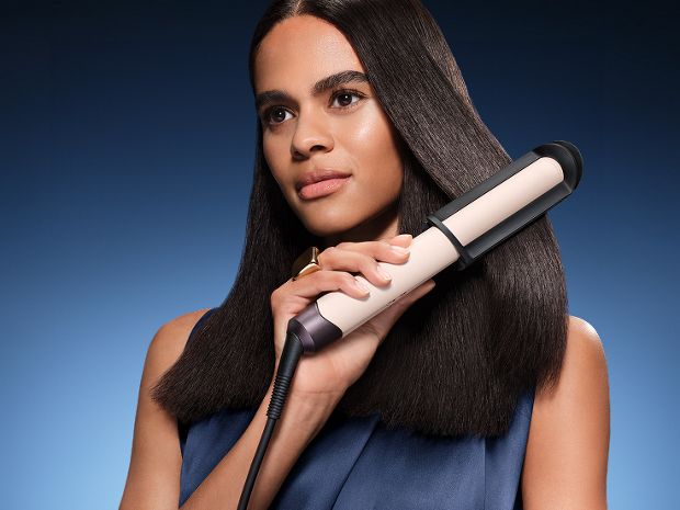 Model straightens her hair with the Dyson Corrale CoolShine hair straightener. in the Dyson Big Ball cylinder vacuum range.
