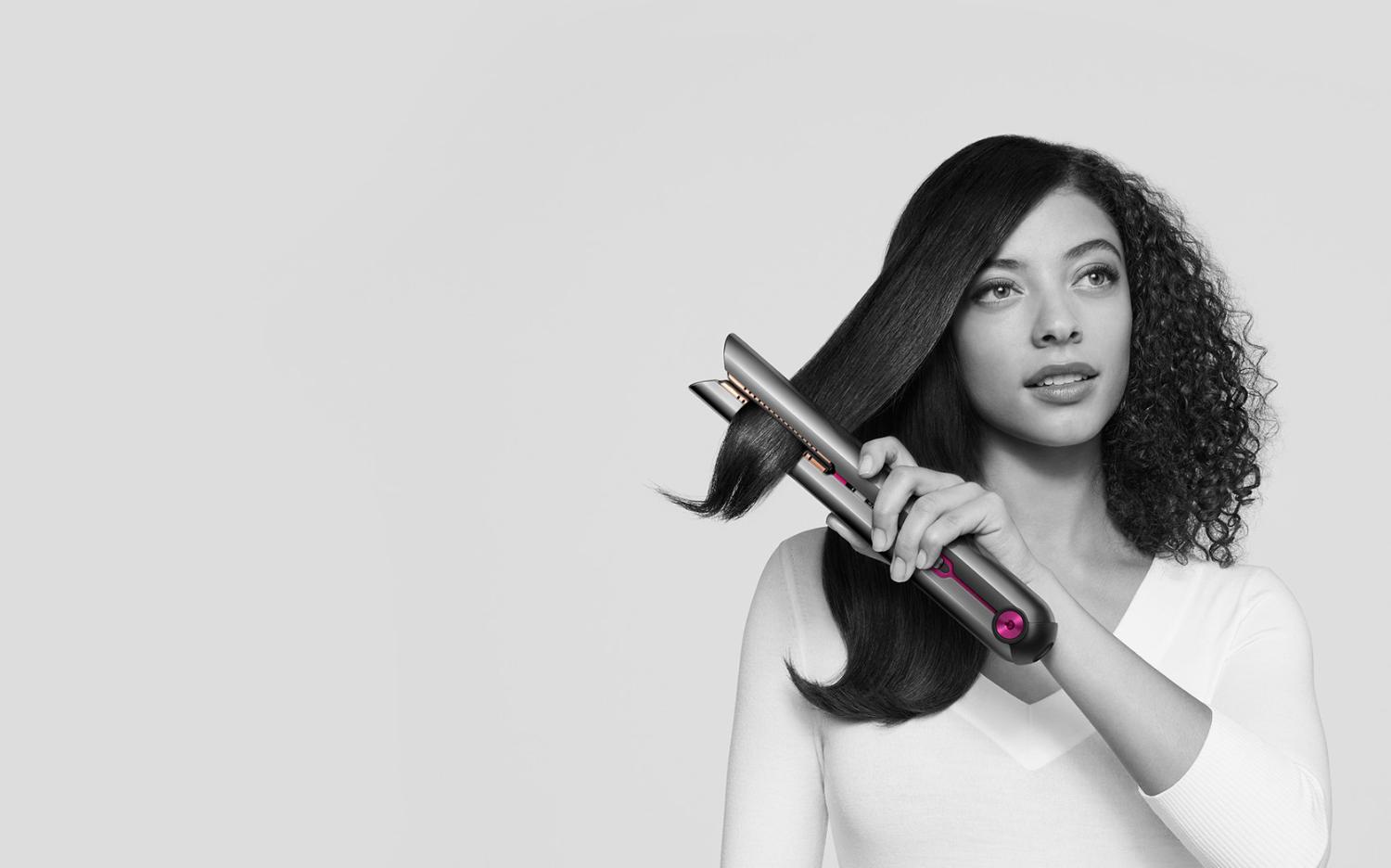 Dyson Corrale straightener being used to straighten curly hair on model