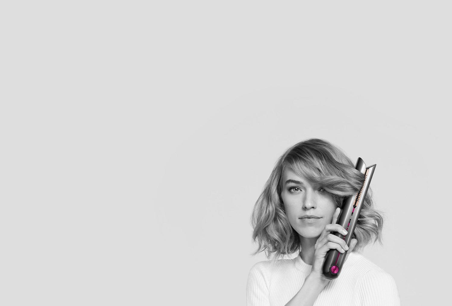 Le fer plat Dyson Corrale créant des boucles sur la chevelure courte d’un mannequin
