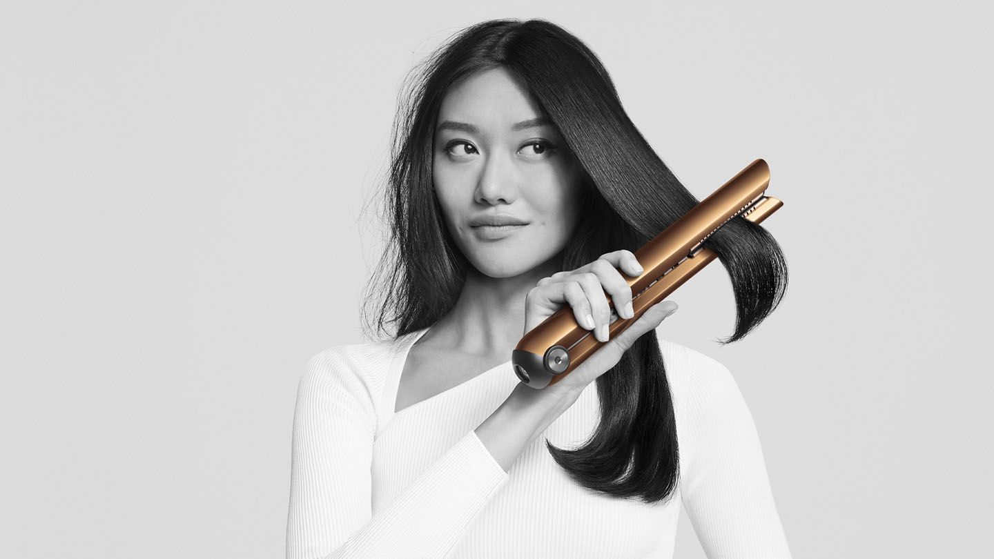 Woman using Dyson Corrale straightener.