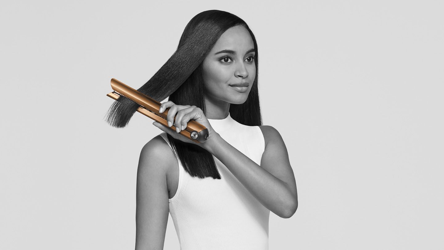 Woman using Dyson Corrale straightener.