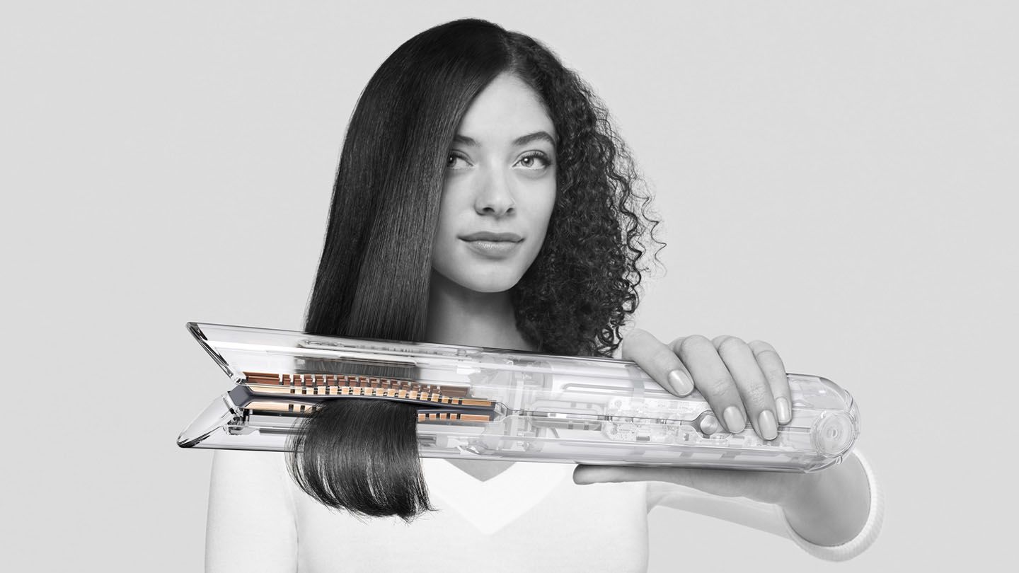 Woman using Dyson Corrale straightener.