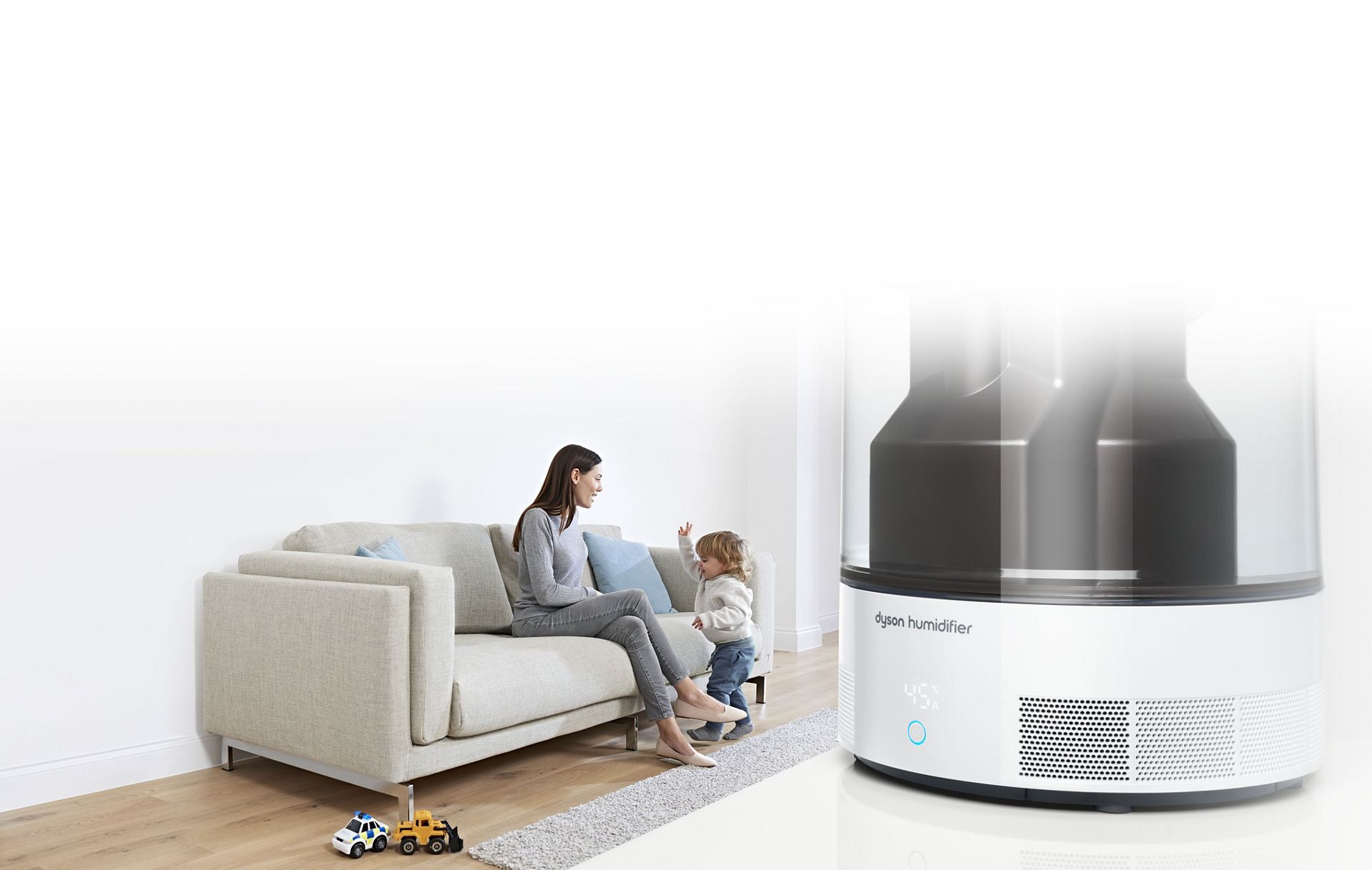 Gros plan sur un humidificateur Dyson, avec mère et son enfant en arrière-plan