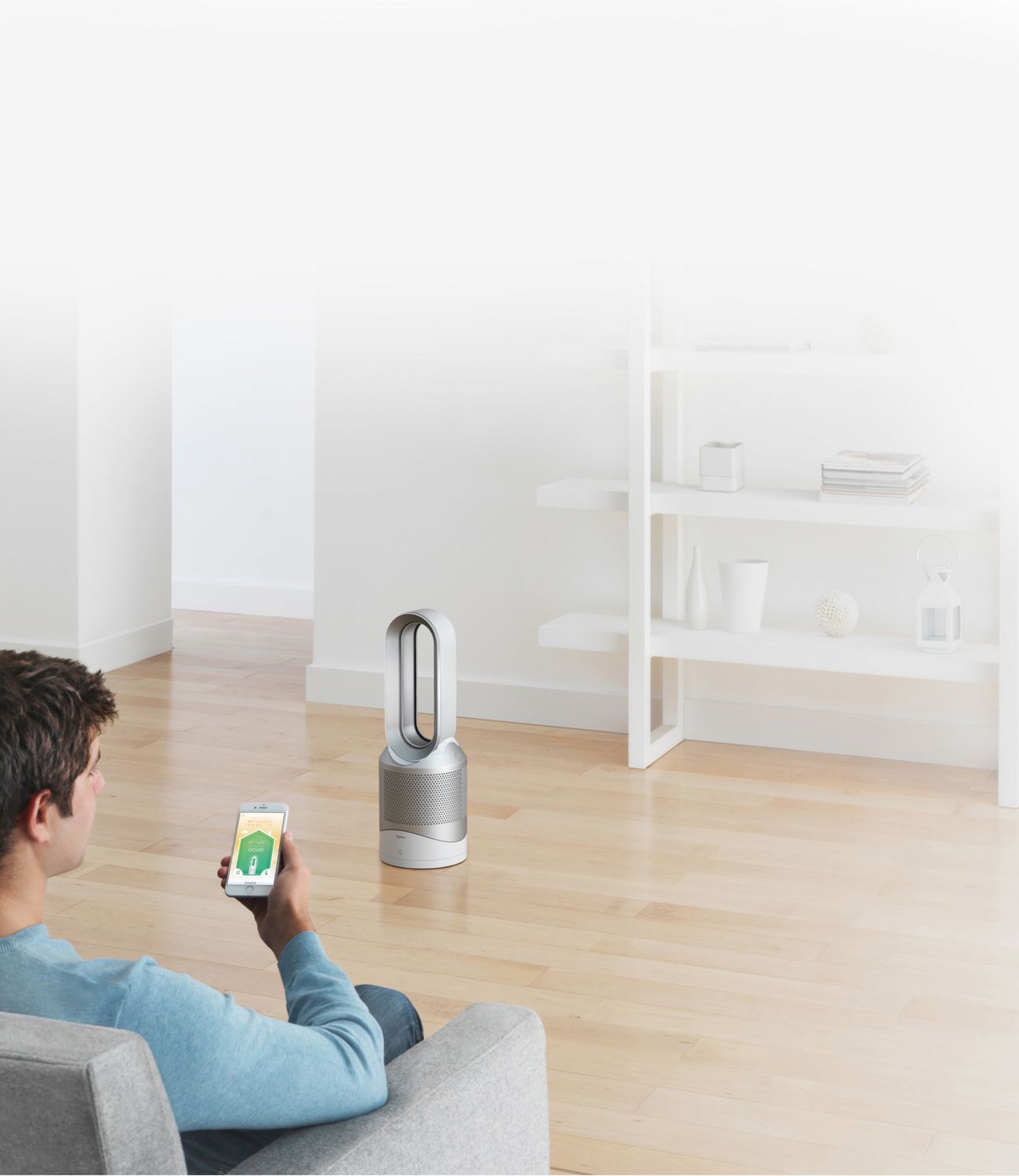 Homme avec un téléphone intelligent et un purificateur Dyson