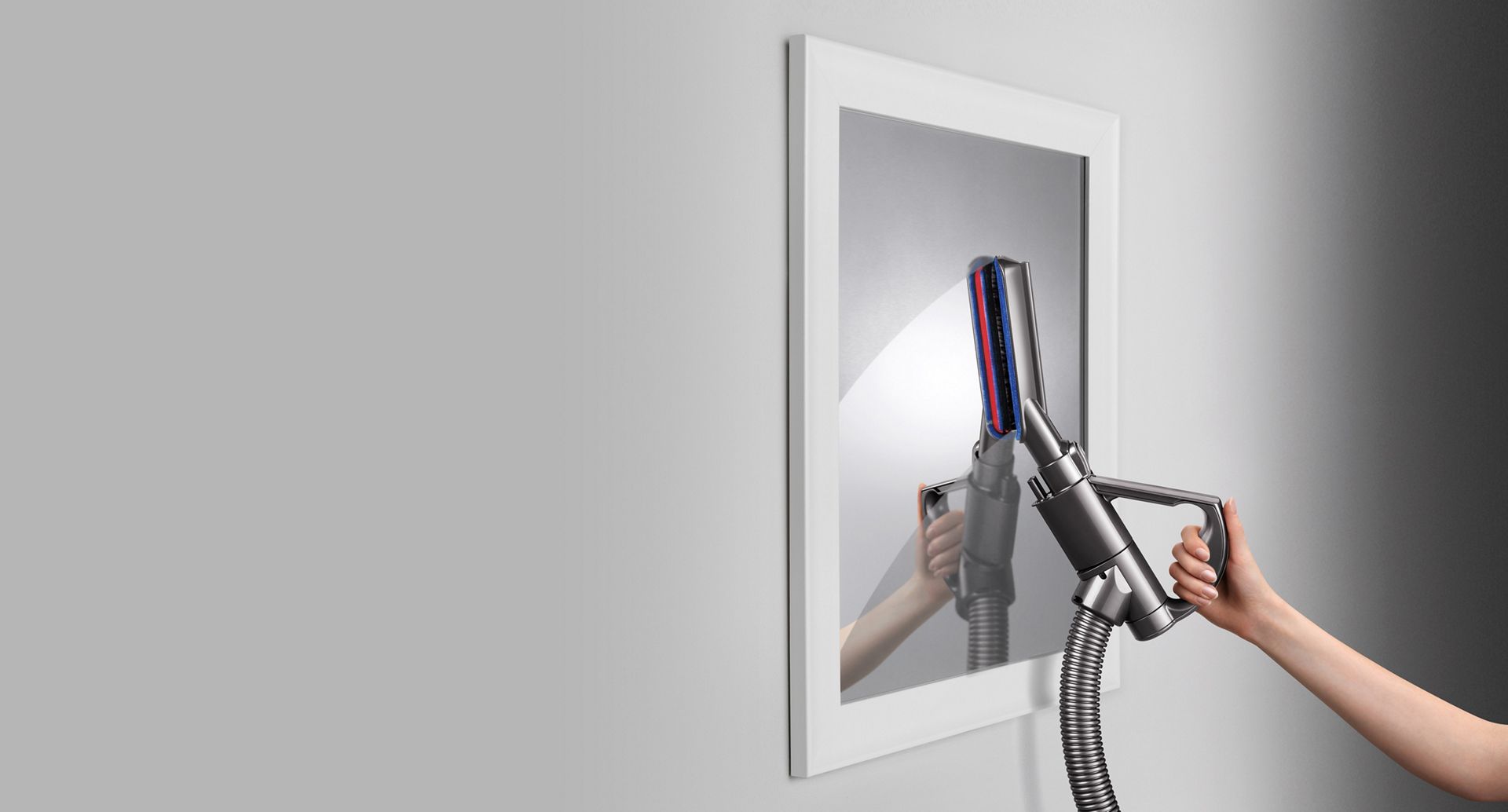 Brosse douce d’époussetage en fibre de carbone sur un miroir.
