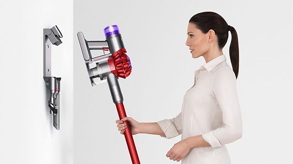 Woman placing Dyson V8 on docking station