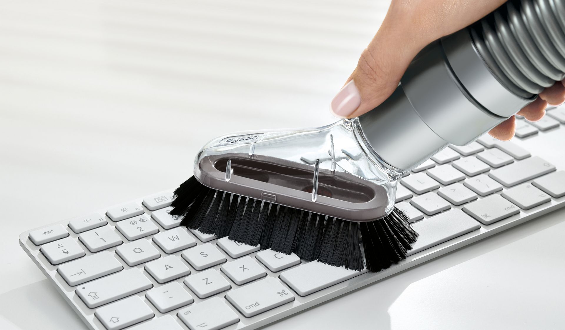 Mini-brosse douce d’époussetage sur un clavier.