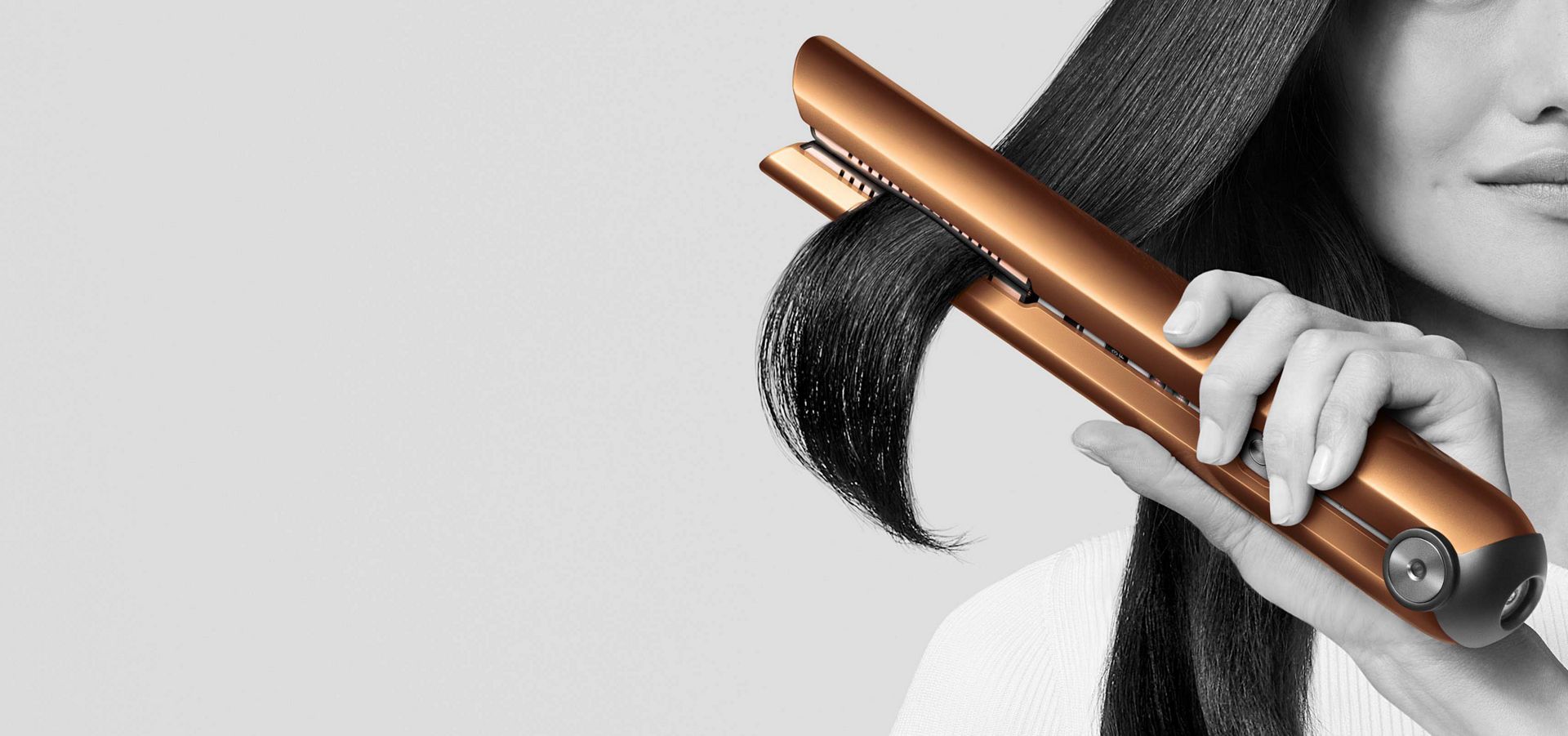 Woman creating a smooth, sleek look with the Dyson Corrale Hair Straightener 