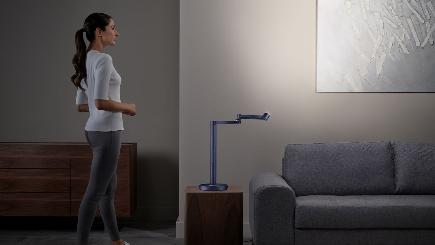 La lampe Dyson Solarcycle Morph est orientée vers le mur, ce qui permet d'éclairer un tableau et de créer une lumière indirecte dans la pièce.