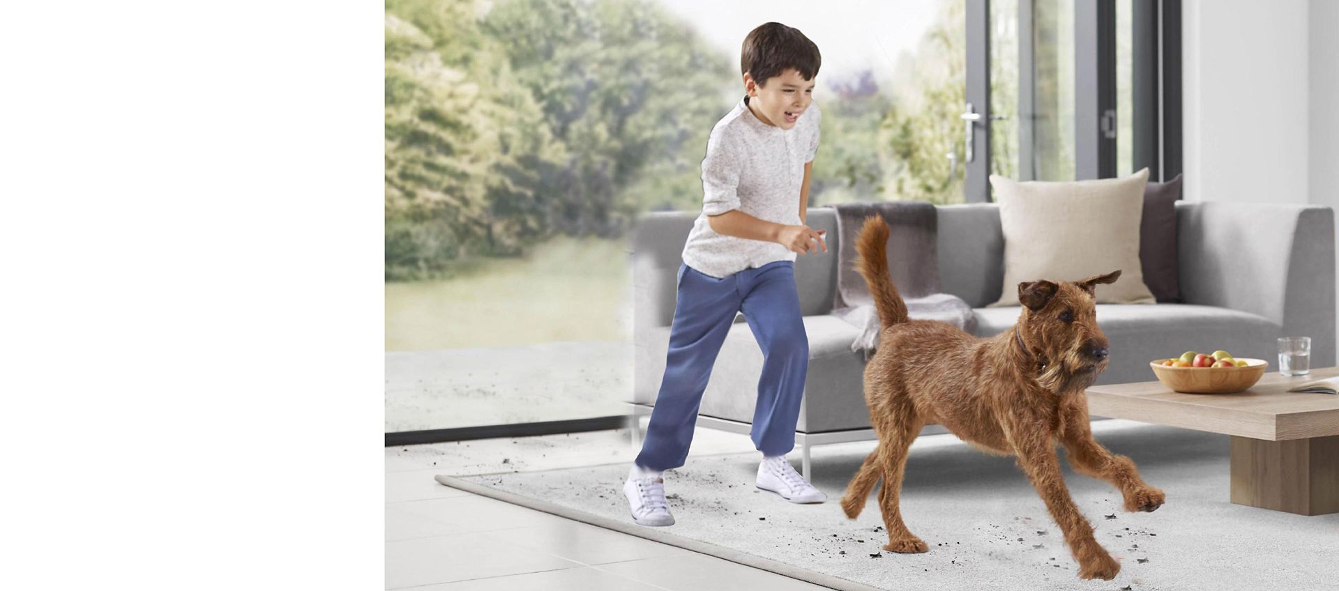 Bambino che corre con un cane in un soggiorno