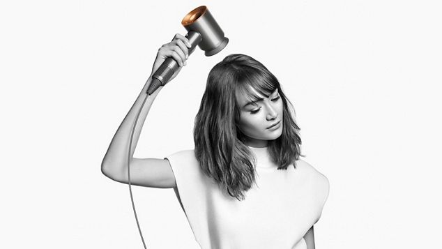 Eine Frau verwendet einen Dyson Supersonic Haartrockner.