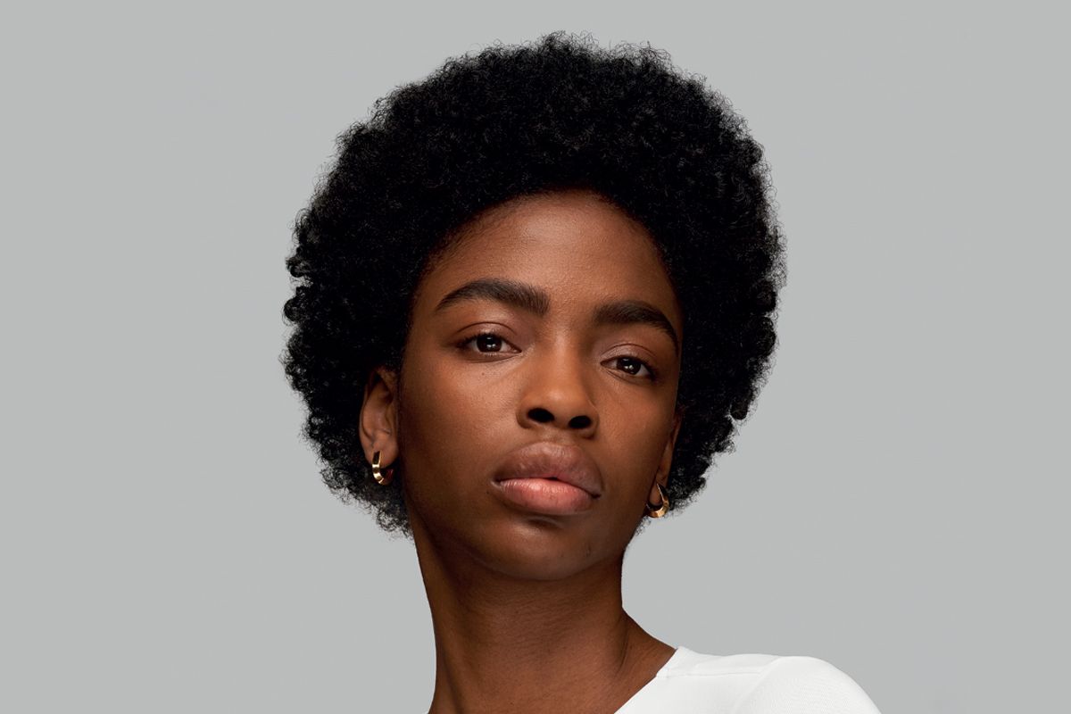 A model with her naturally coily hair styled into a Soft Twist style using the Dyson Supersonic r hair dryer.