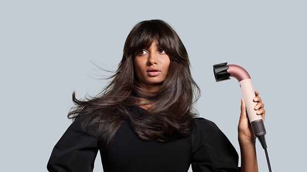 Kobieta susząca włosy suszarką Dyson Supersonic r