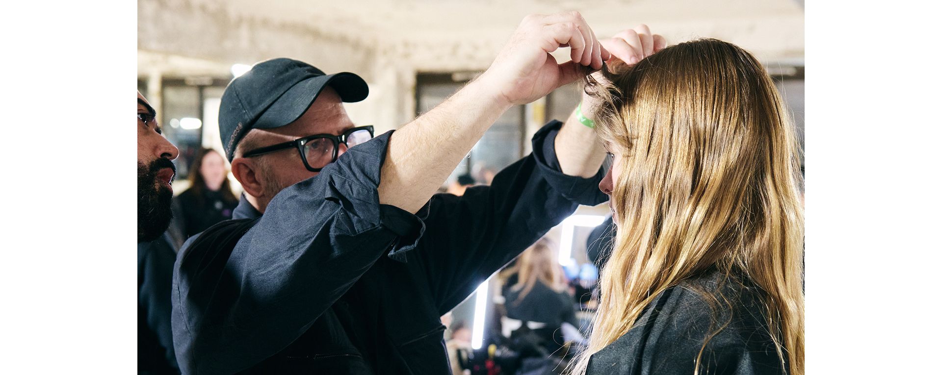 Profesjonalny stylista dodaje ostatnie szlify fryzurze modelki
