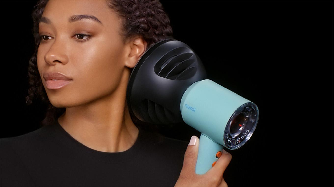 A model using the Wave+Curl diffuser on the Dyson Supersonic Nural hair dryer