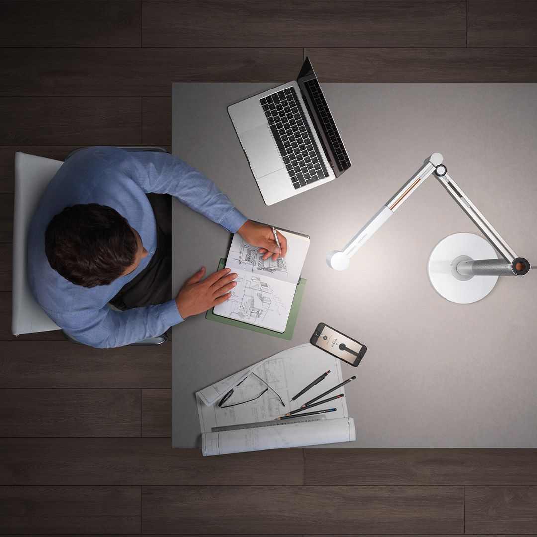 Dyson Solarcycle Morph desk lamp illuminating a work station