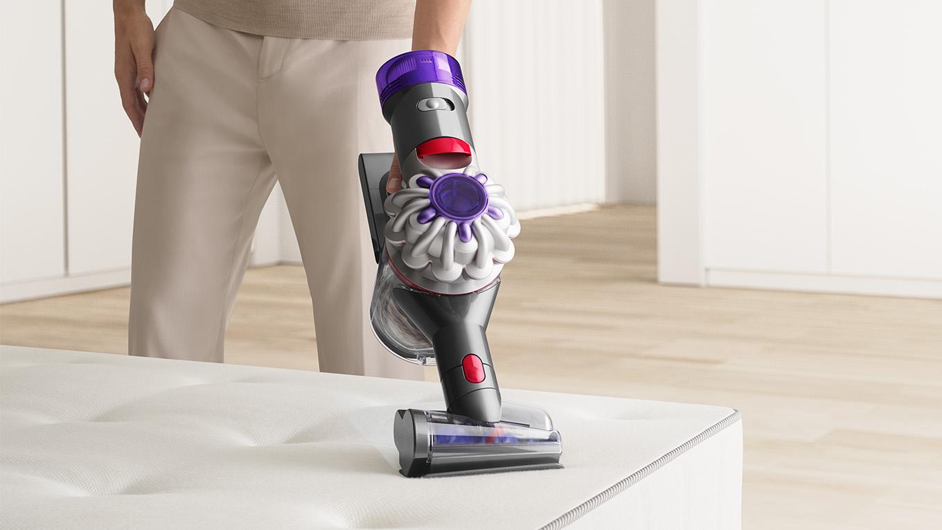 Dyson handheld vacuum vacuuming couch