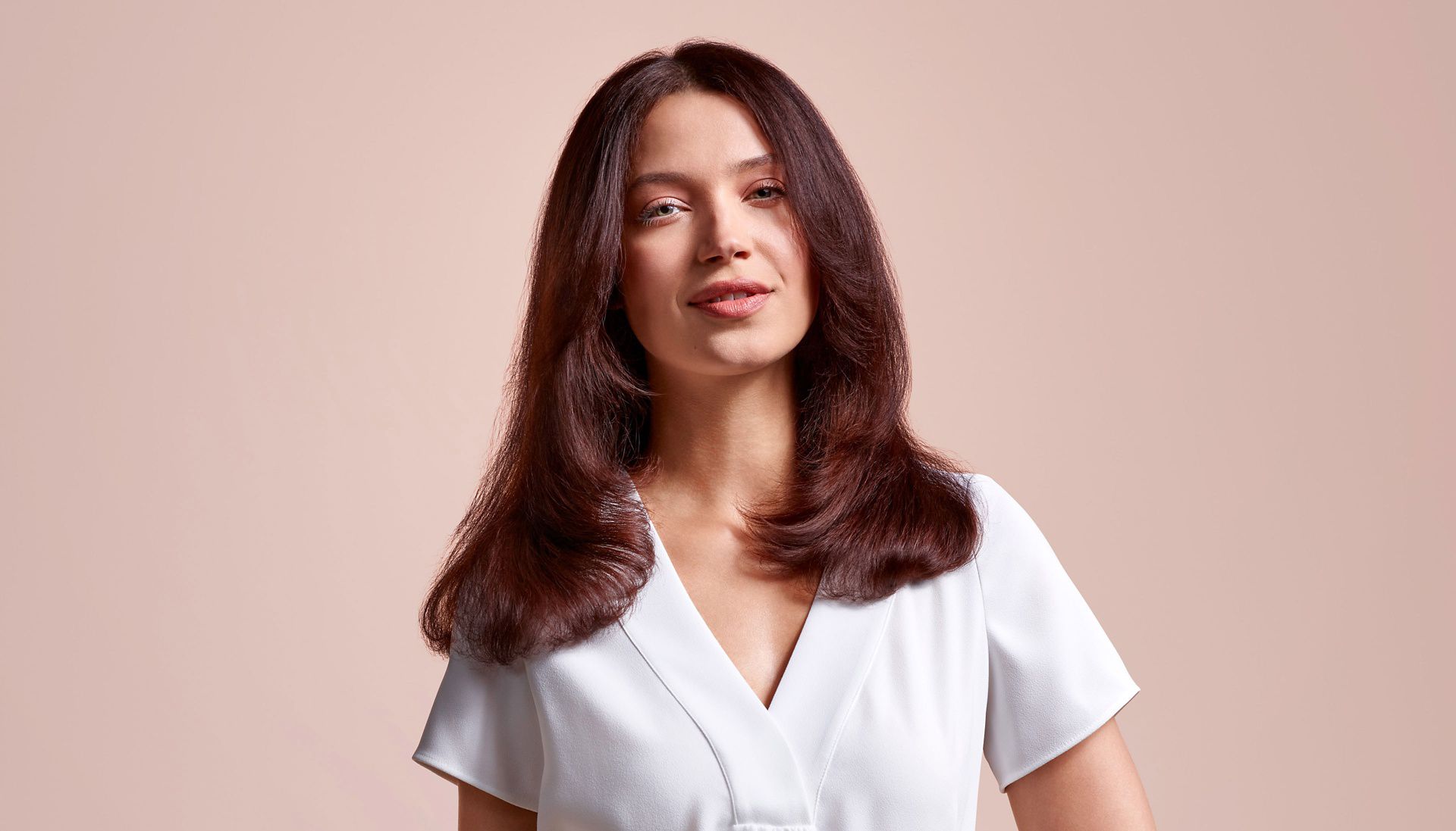 Uma mulher com um penteado reto inspirado nos anos 90, feito com o alisador Dyson Airstrait™