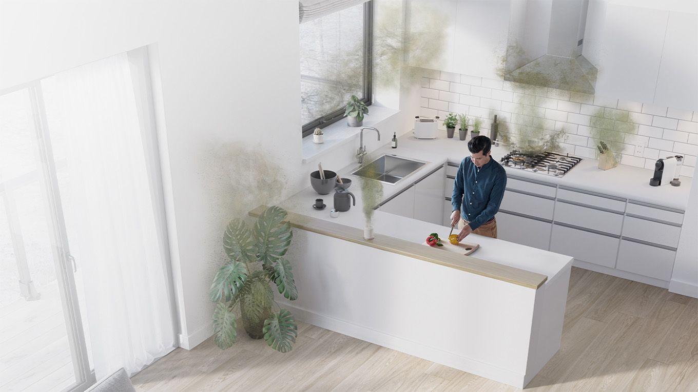 A high-angle view of a studio apartment with graphic overlays showing sources of pollution including a plant and a kitchen stove.