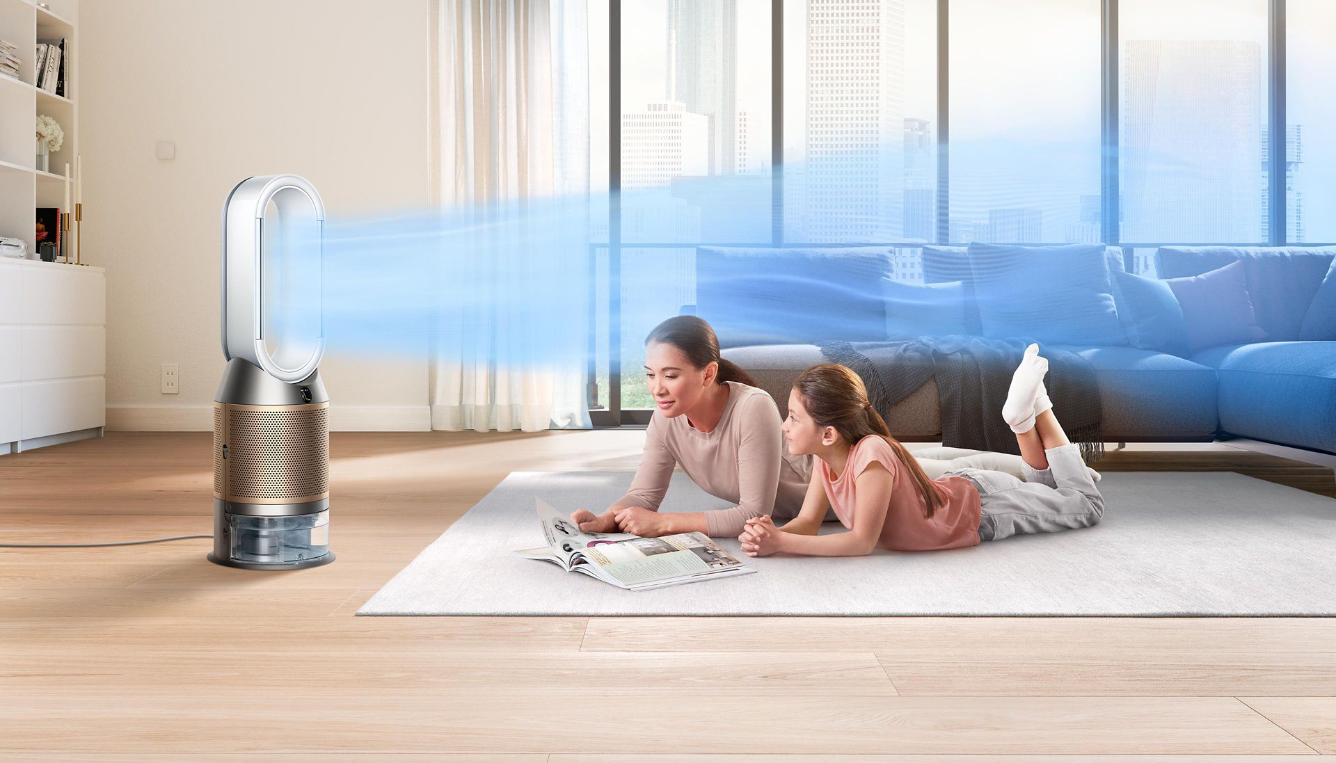 Dyson air purifier circulating cleaner air while mother and daughter lie down reading magazine on living room rug