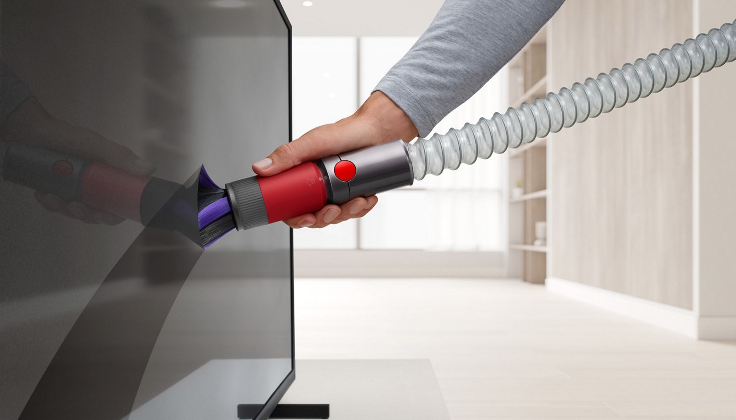 Dyson Extension hose with Soft dusting brush used to dust TV in living room